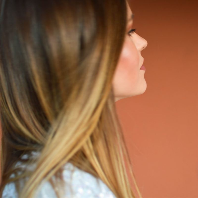 顔まわりにレイヤーを入れたロングヘアの横顔